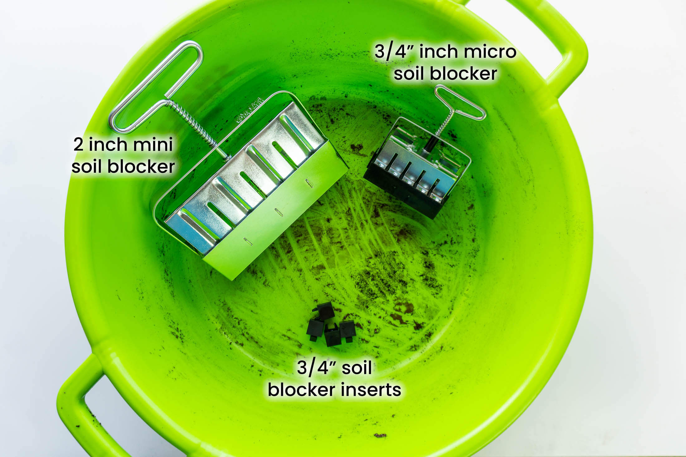 Mini and micro soil blocker in a green feed tub.
