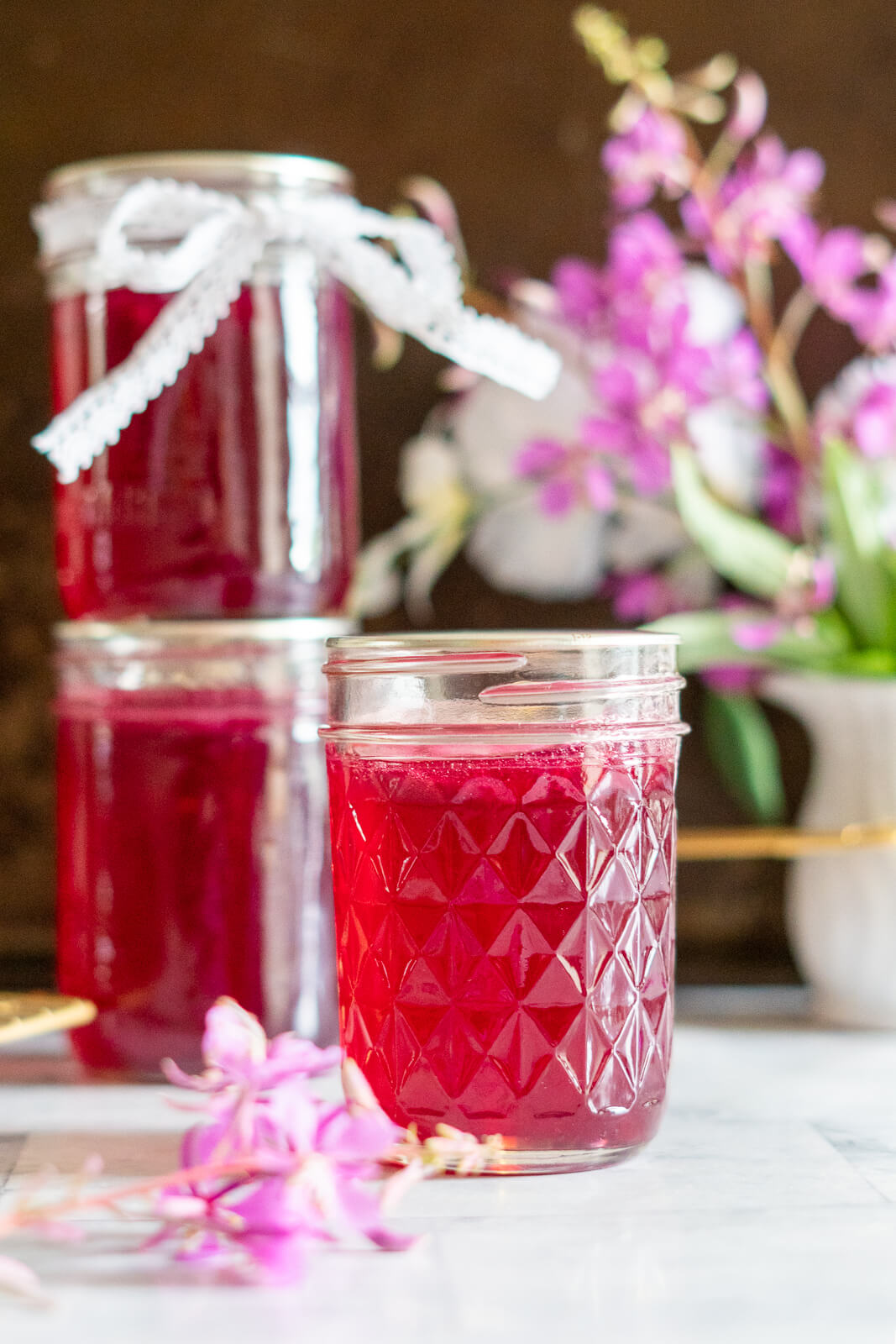 3 bright pink jars of fireweed jelly. 