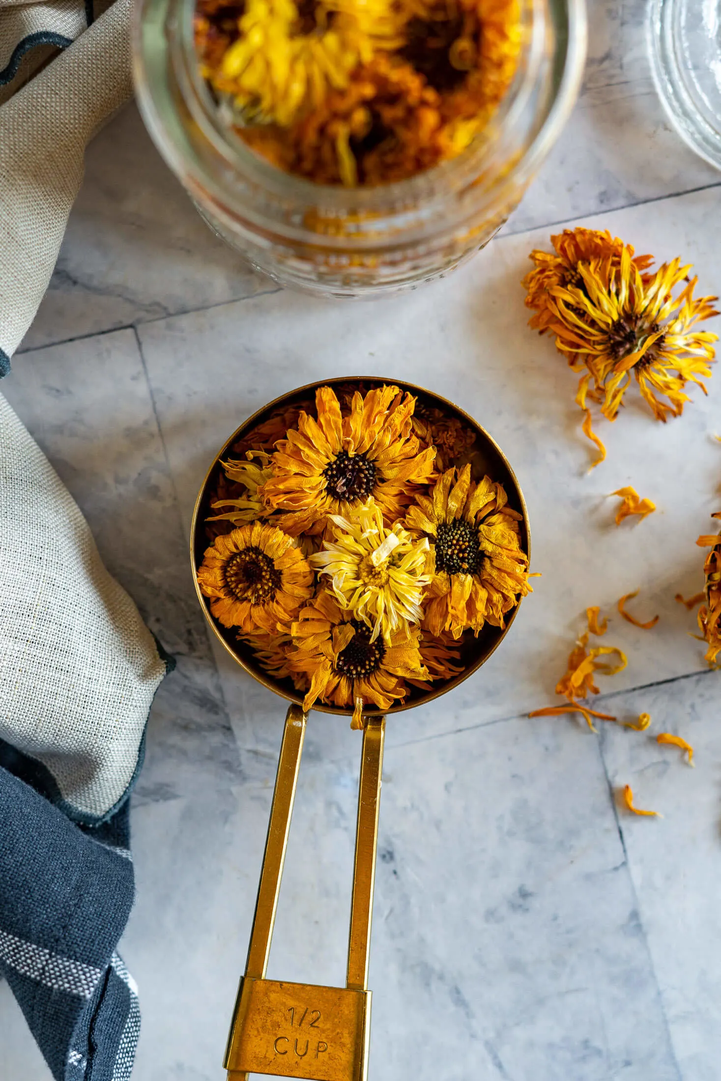 Dry calendula blossoms in a measuring cup. 