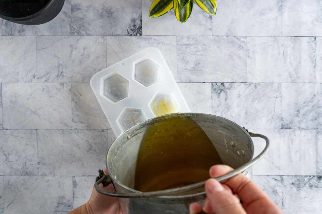 Pouring wax into prepared molds. 