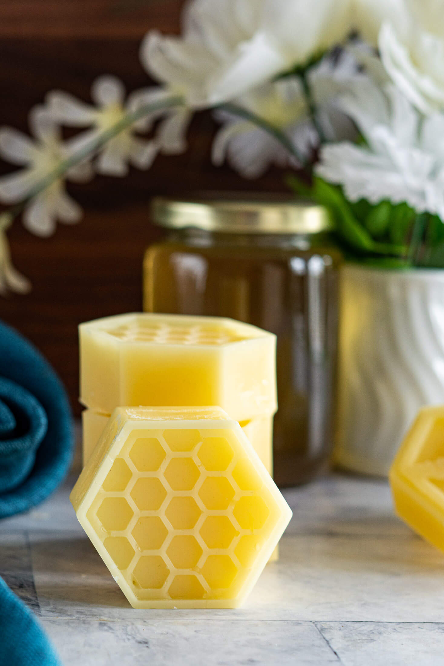 Stacked rendered beeswax chunks with a jar of honey. 